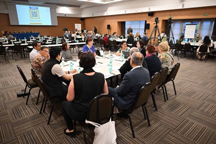 SPAGN-konferenssin ryhmäkeskustelua, ihmisiä kokoushuoneessa pöydän ympärillä keskustelemassa. Kuva: Uli Deck