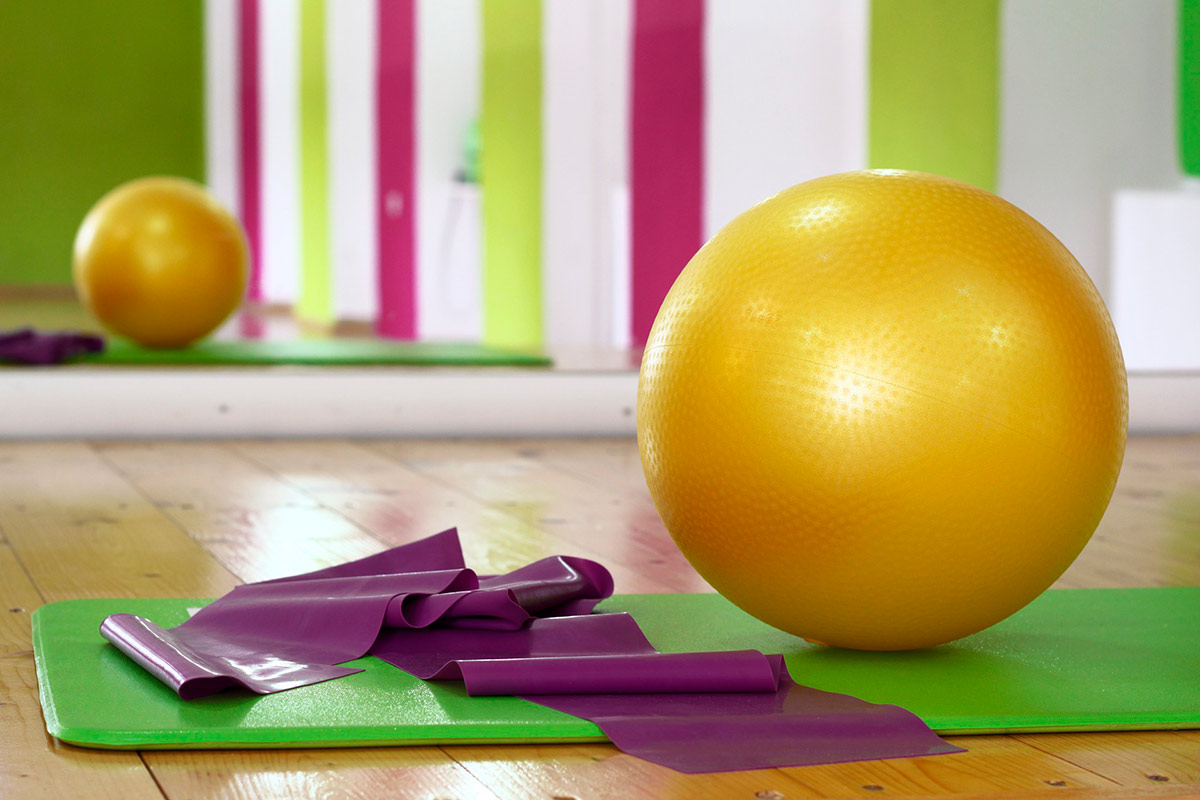 Jumppapallo, kuminauha ja jumppamatto pilatesstudion lattialla