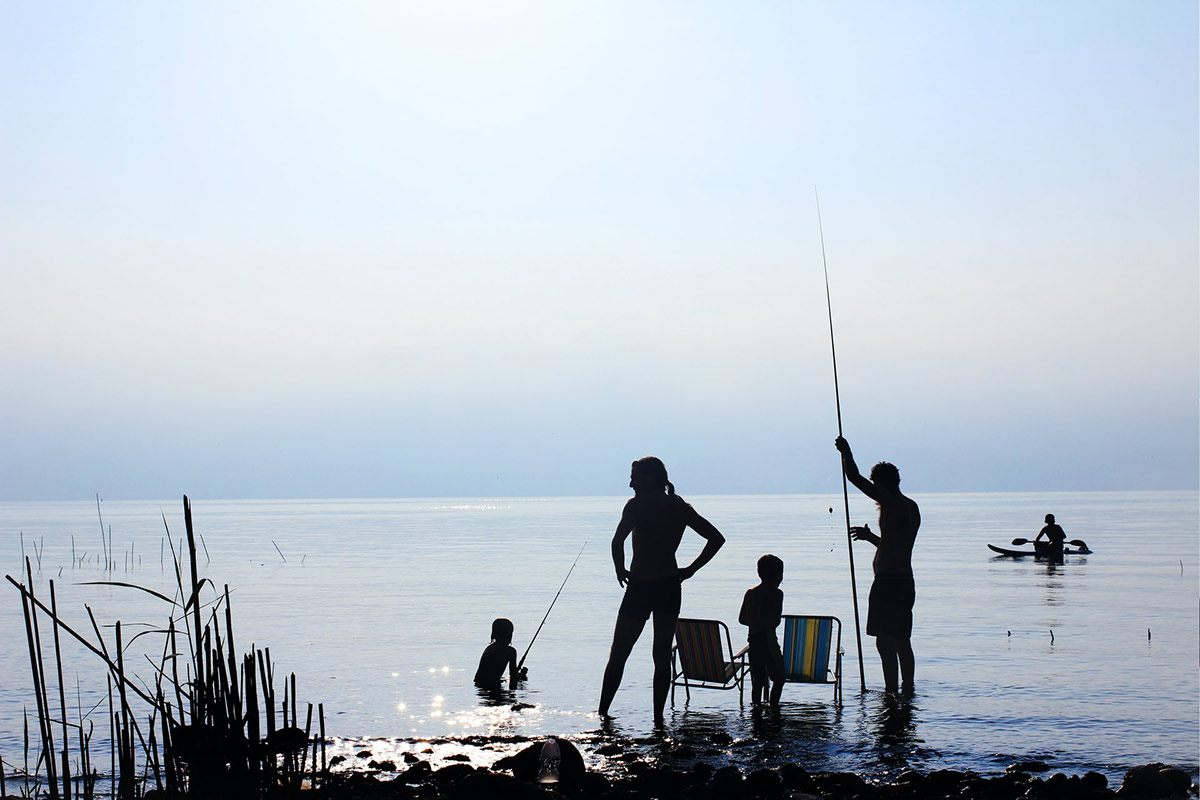 Perhe kalastaa rantavedessä